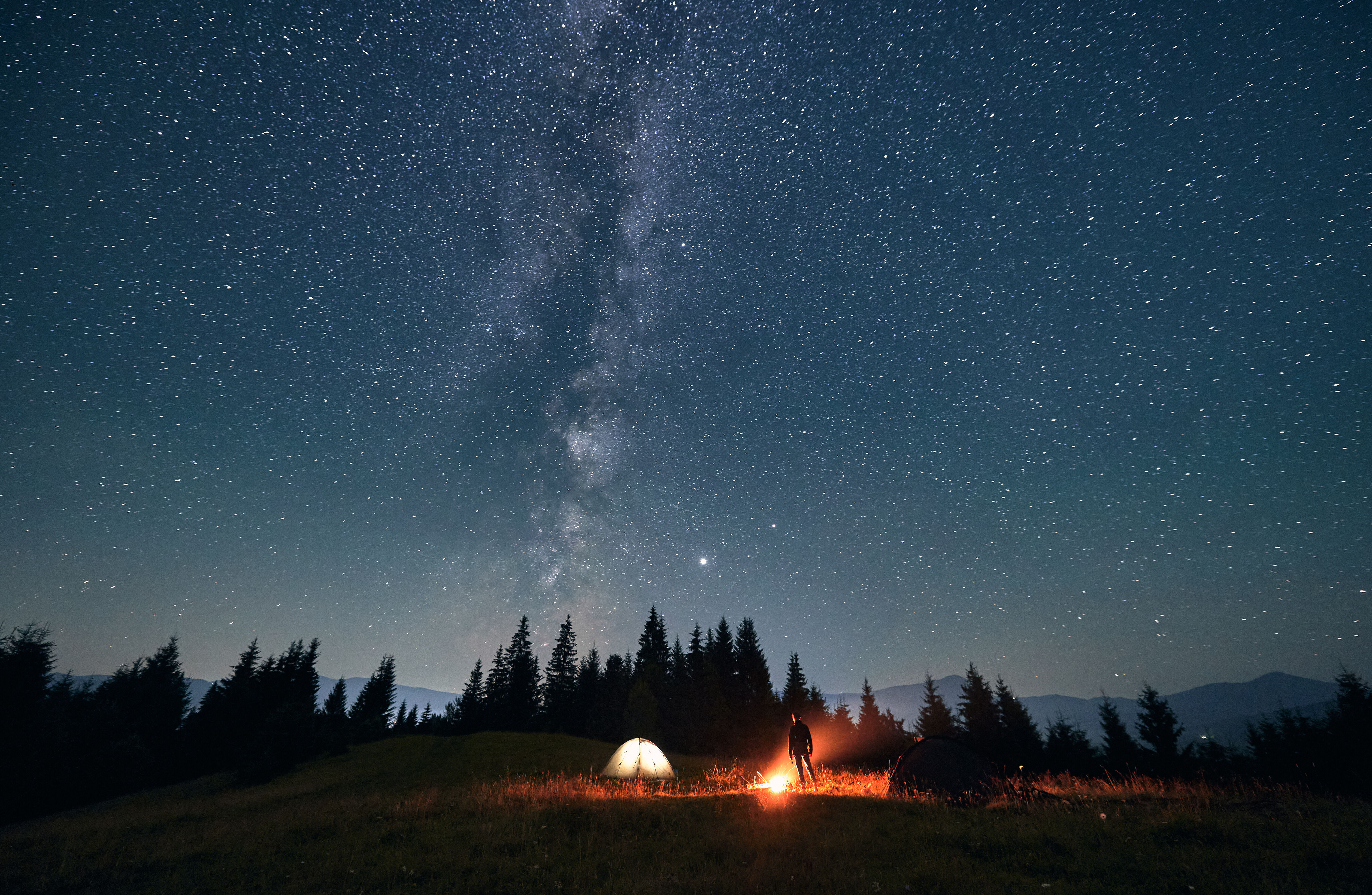 A camp set up under the starry night sky. 