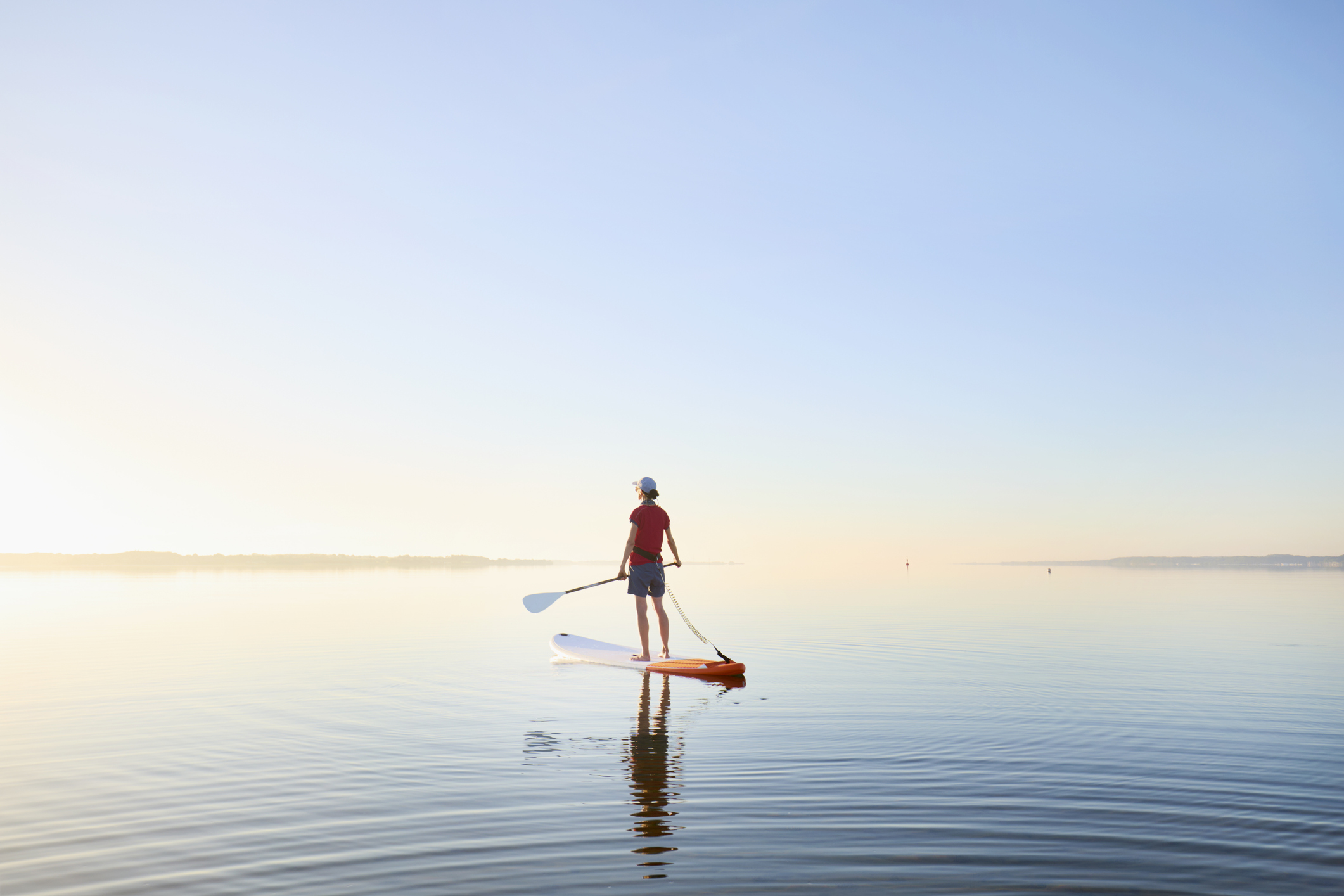 A photo of a woman on a paddleboard. 