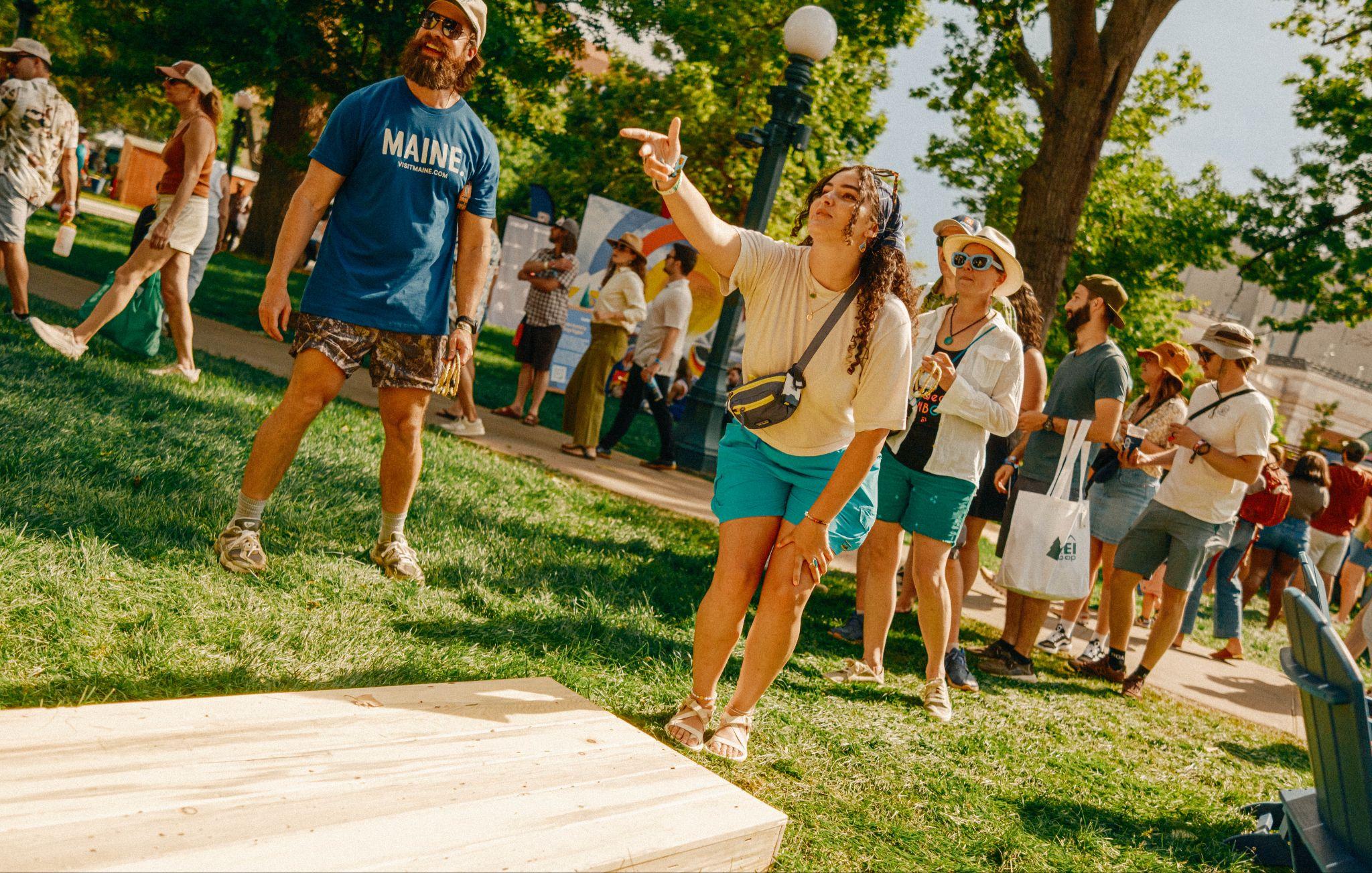A photo of a woman playing cornhole
