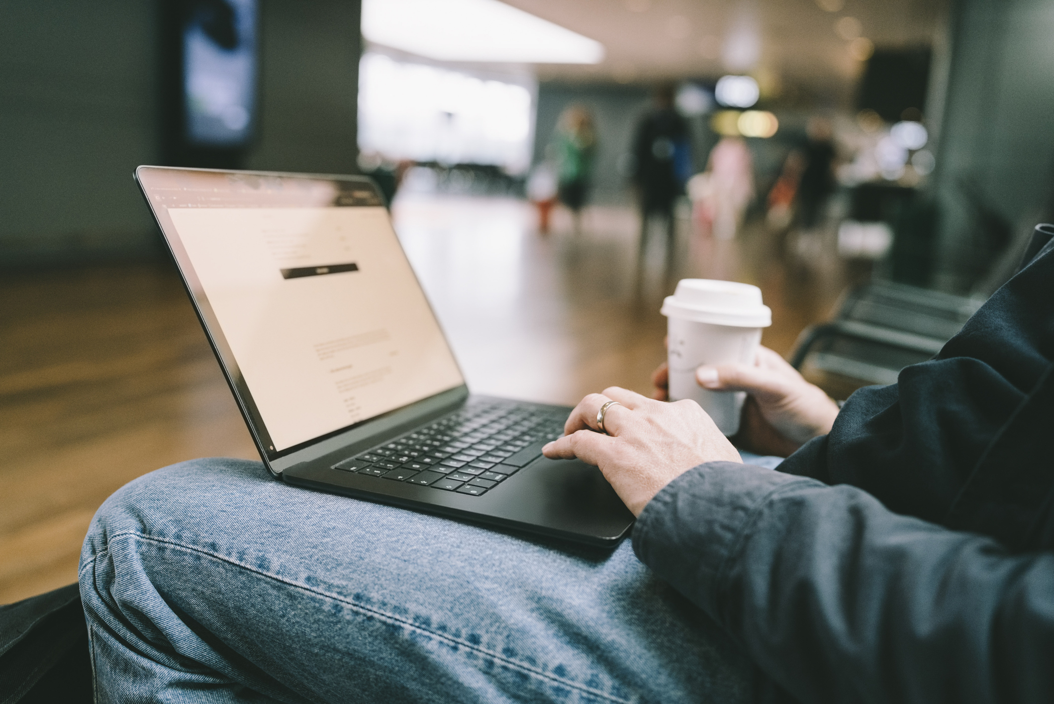 A man typing on his laptop while drinking coffee. 