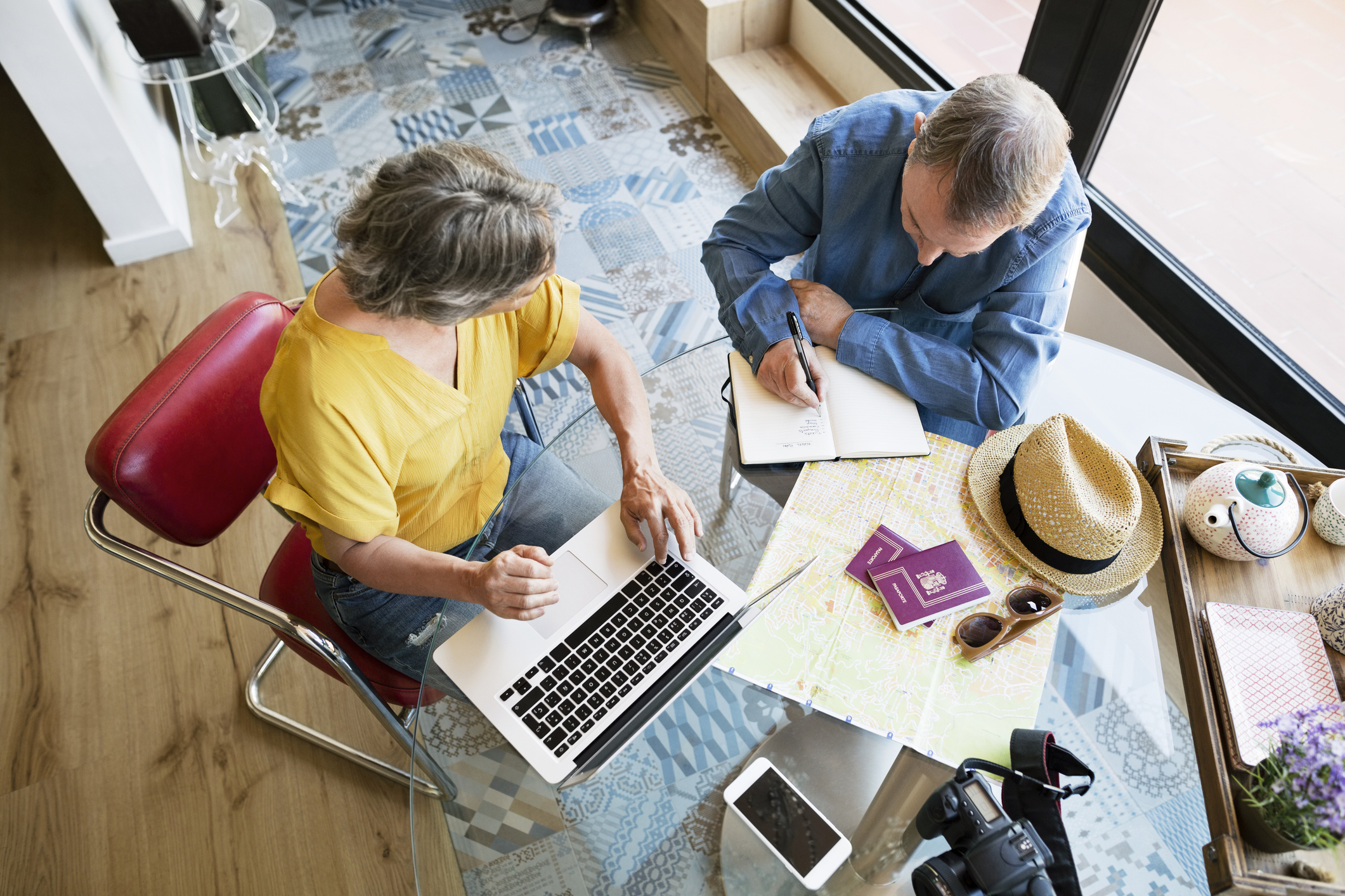 Overhead view of senior couple planning vacation at home
