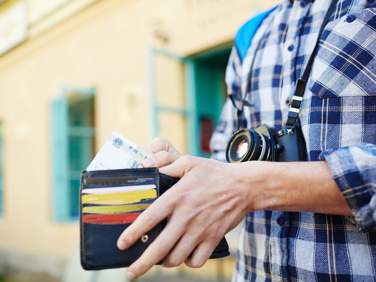 A closeup shot of a tourist taking money out of his wallet. 