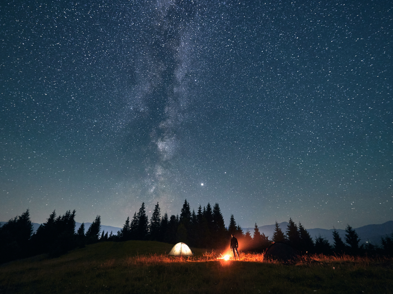 A camp set up under the starry night sky. 