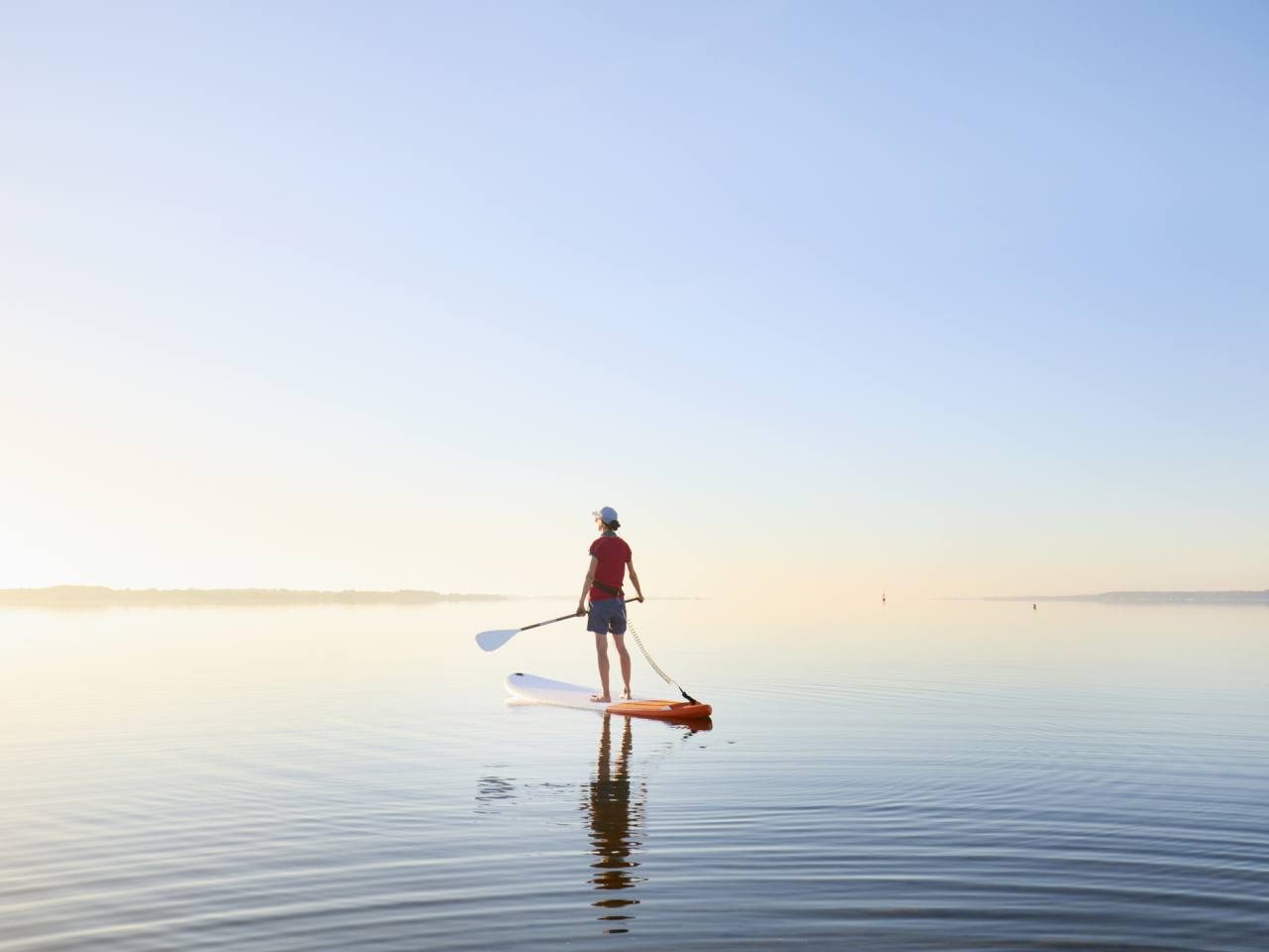 A photo of a woman on a paddleboard. 
