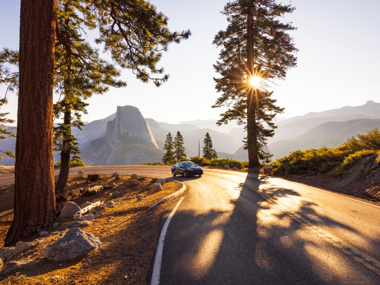 A photo of a car driving through a scenic location. 