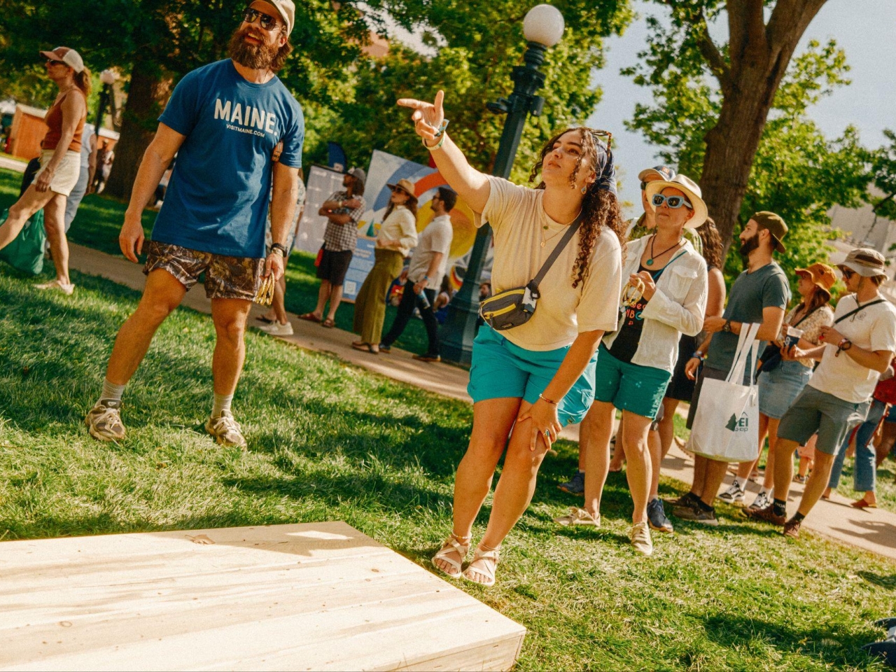 A photo of a woman playing cornhole