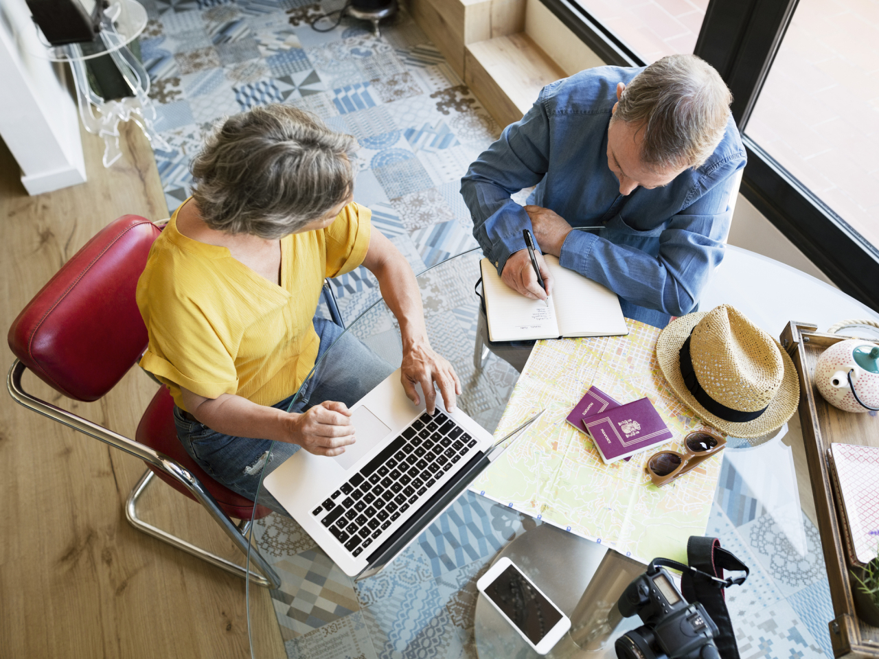 Overhead view of senior couple planning vacation at home
