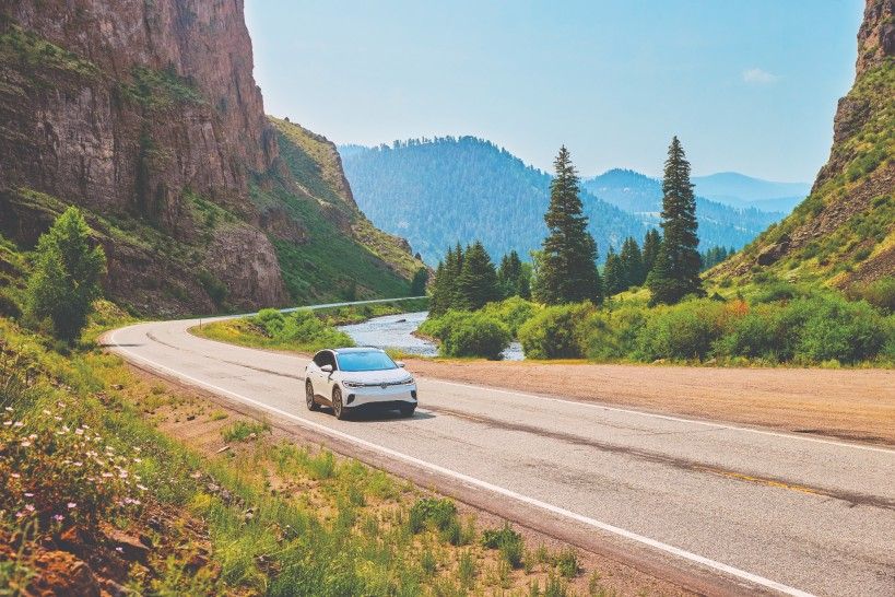 An electric vehicle driving through the Colorado mountains. 