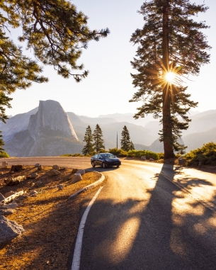 A photo of a car driving through a scenic location. 