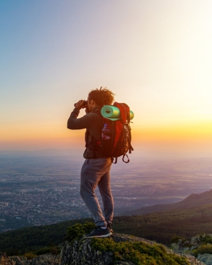 A photo of a man looking through binoculars