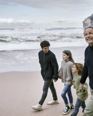 A photo of a family walking down the beach