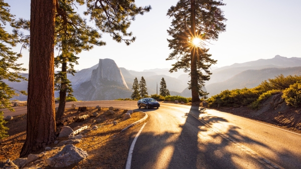 A photo of a car driving through a scenic location. 