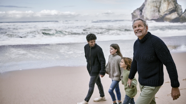 A photo of a family walking down the beach