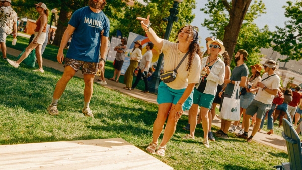 A photo of a woman playing cornhole
