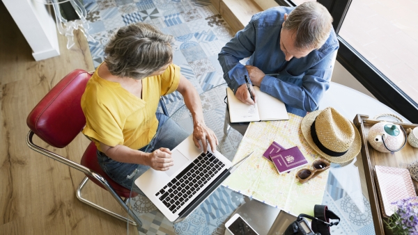 Overhead view of senior couple planning vacation at home