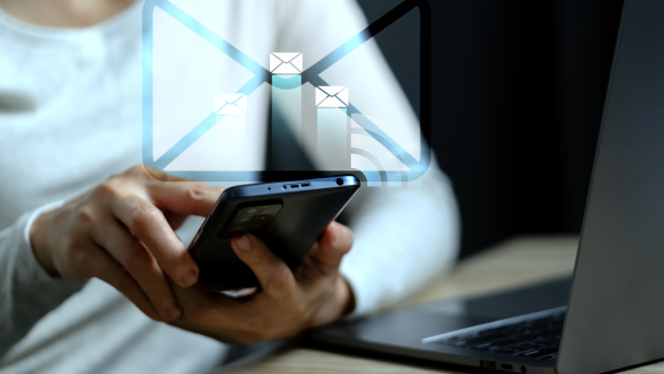 A woman browses through emails on her phone. 