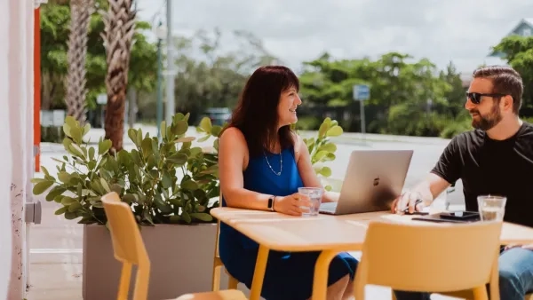 A photo of Kim Palmer and Neal Alfano chatting outside a shop. 