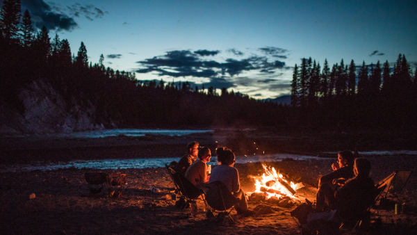 A group of people hanging out by a campfire. 