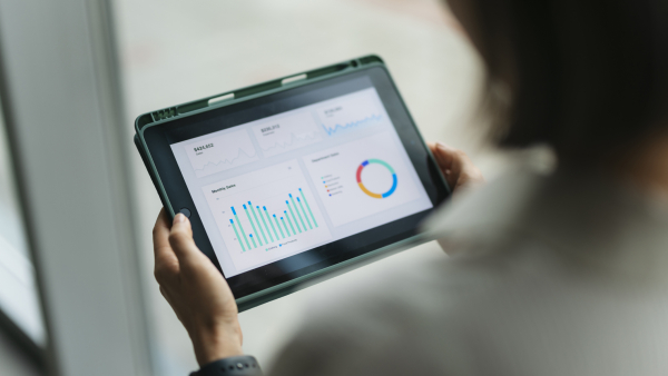 A photo of a person analyzing research on a tablet. 
