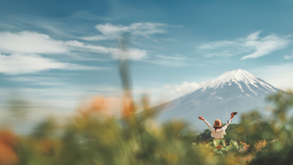 A woman raising her arms in front of Mt. Fuji. 