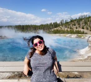 Yasaman Roostaeian in front of a bright blue pool at Yellowstone National Park