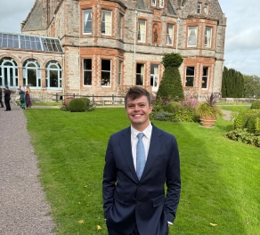 A photo of August posing near a historical building. 