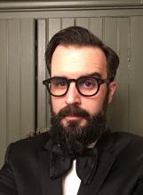 Patrick Rodgers headshot with black glasses