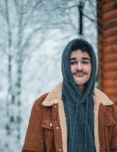 A picture of Andy next to a cabin in snowy Tennessee