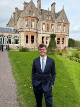 A photo of August posing near a historical building. 