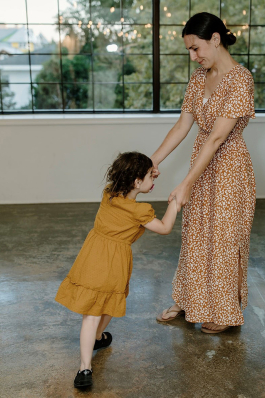 Aimee Kohler and child holding hands dancing
