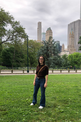 Amanda Pfeil standing in the grass in Central Park with tall buildings in the background