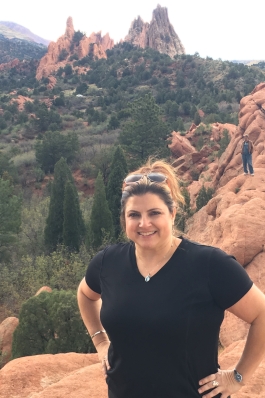 Andraya Ticola standing in a red-rock landscape with buttes behind her