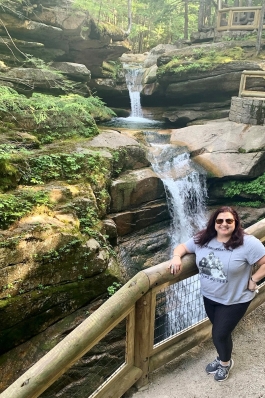 Andraya Ticola stands by railing of a waterfall overlook