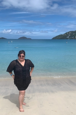 Andraya Ticola on a shoreline with islands and bright blue water in the backgrond