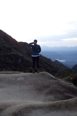 Carson Young looking out in the Andes mountains of Peru from an erosion-worn rock formation