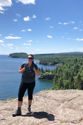 Chelsea Mikesell on a rock ledge in front of a lake