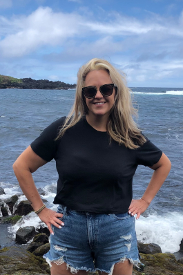 Christine Johnson in front of the rocky shoeline on Kauai