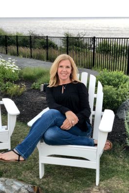 Debbie Johnson on an Adirondack chair in coastal Maine
