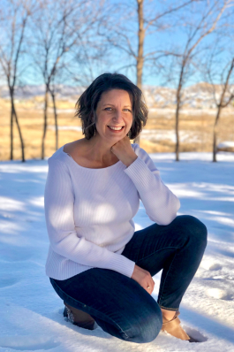 Kelly Brown kneeling in the snow in Colorado