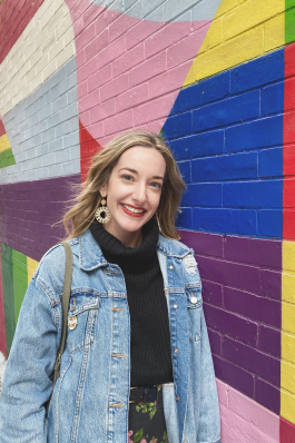 Lindsay Pace in front of a colorful muraled wall