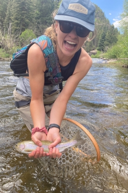 Mattie Hall shows off a rainbow trout she netted in Montana