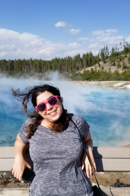 Yasaman Roostaeian in front of a bright blue pool at Yellowstone National Park