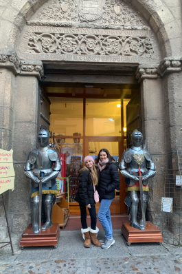 Megan Bookhammer alongside knights' suits of armor in Toledo, Spain