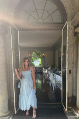 Andrea Valentini standing in a doorway in a blue dress