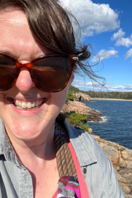 A photo of Katie with a lake back drop