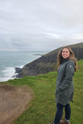 A photo of Holly near a cliff overlooking an ocean