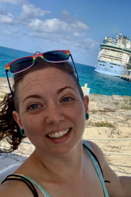 A photo of Jesi with the ocean and a cruise ship in the background. 