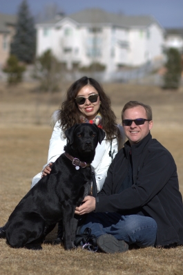 A photo of Wenjie and a dog in a Denver field. 