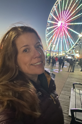 A selfie of Rachel next to a Ferris wheel. 