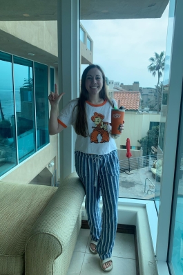 A photo of Andi standing next to a window.